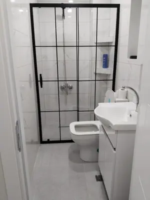 a bathroom with a shower and a toilet and a sink at White garden in Tuzla
