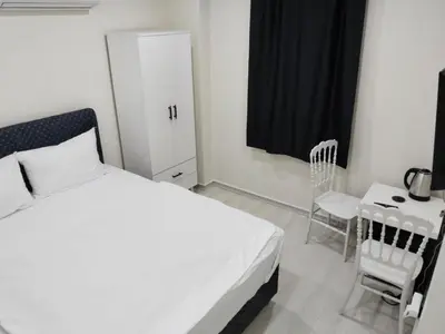 a bedroom with a white bed and a chair at White garden in Tuzla