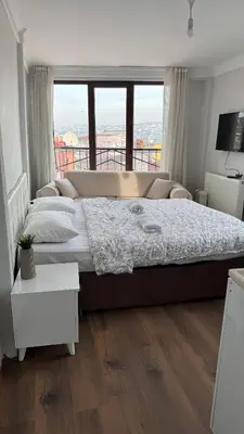 a bedroom with a large bed with a large window at balatlife suites in Istanbul
