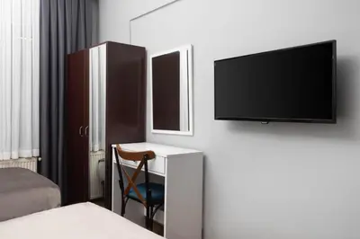 a room with a tv and a desk with a chair at Babil Hotel in Istanbul