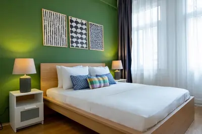 a bedroom with a white bed with a green wall at 3-Bedroom 2-Bathroom, Centrally Located Ground-Floor Apartment -No Stairs in Istanbul