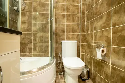 a bathroom with a toilet and a shower at 3-Bedroom 2-Bathroom, Centrally Located Ground-Floor Apartment -No Stairs in Istanbul