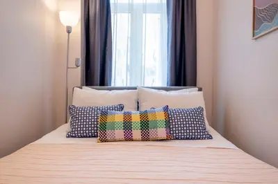 a bed with pillows on it with a window at 3-Bedroom 2-Bathroom, Centrally Located Ground-Floor Apartment -No Stairs in Istanbul