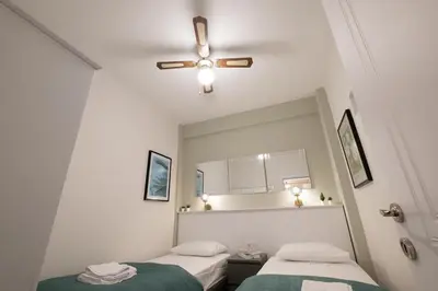 a bedroom with two beds and a ceiling fan at Fully Renovated 2BR Flat in Center of Moda in Istanbul
