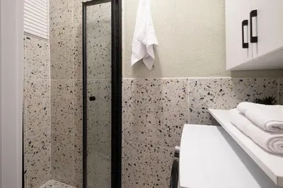 a bathroom with a shower with a toilet and a sink at Fully Renovated 2BR Flat in Center of Moda in Istanbul