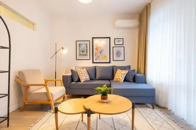a living room with a blue couch and a table at Fully Renovated 2BR Flat in Center of Moda in Istanbul