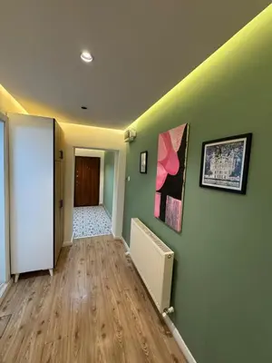 an empty hallway with green walls and wooden floors at Veva corner suit in Istanbul