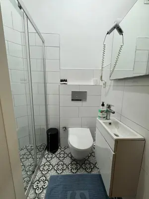 a white bathroom with a toilet and a sink at Veva corner suit in Istanbul