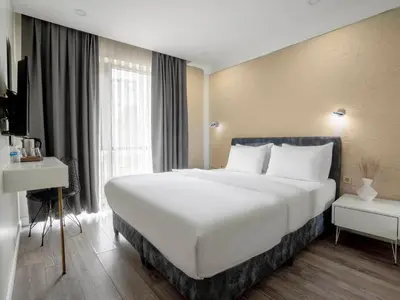 a large white bed in a room with a window at Actuel Life Hotel in Istanbul