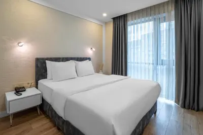 a large white bed in a room with a large window at Actuel Life Hotel in Istanbul