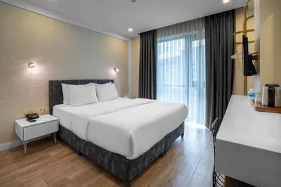 a bedroom with a large white bed and a window at Actuel Life Hotel in Istanbul