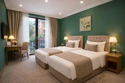 two beds in a hotel room with green walls at İSTANBUL ESRA Hotel in Istanbul