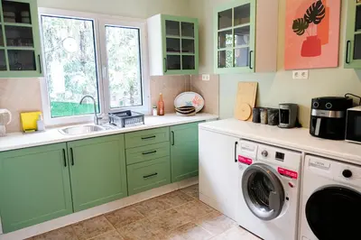 a kitchen with green cabinets and a washer and dryer at Terrazzo Sapanca - Isıtmalı Havuzlu Villa Verde in Sapanca