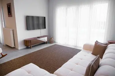 a living room with a white couch and a flat screen tv at Terrazzo Sapanca - Isıtmalı Havuzlu Villa Sole in Sapanca