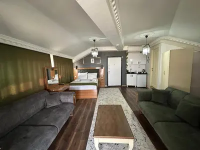a living room with a couch and a bed at Riwaner Hotel in Avcılar