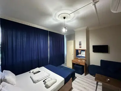 a hotel room with a bed and a blue curtain at Riwaner Hotel in Avcılar