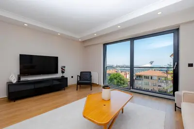 a living room with a tv and a large window at Sea View Two-Bedroom Suite in Managed Residence - Parking and Elevator in Istanbul