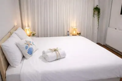 a white bed with two white pillows and two lamps at balatlifesuites in Istanbul