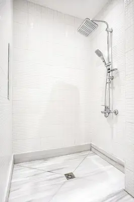a shower in a white tiled bathroom at A Modernized Apt In The Historic Area Of Istanbul in Istanbul