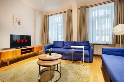 a living room with a blue couch and a tv at A Modernized Apt In The Historic Area Of Istanbul in Istanbul
