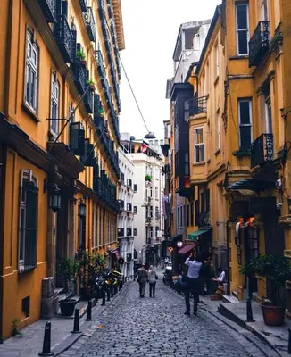 a group of people walking down a street with buildings at A Modernized Apt In The Historic Area Of Istanbul in Istanbul