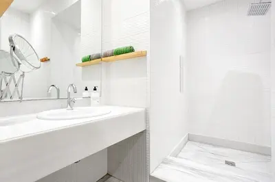 a white bathroom with a sink and a tub at A Modernized Apt In The Historic Area Of Istanbul in Istanbul