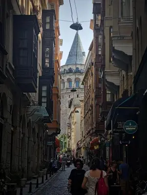 a group of people walking down a street with a building at A Modernized Apt In The Historic Area Of Istanbul in Istanbul