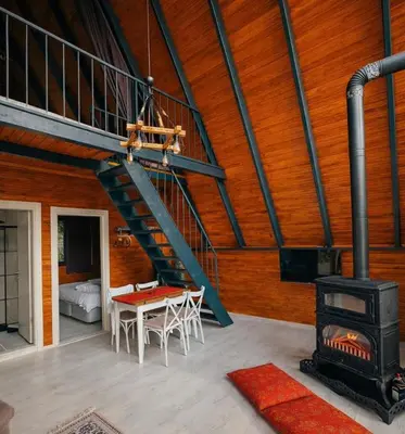 a room with a staircase and a table and a stove at Alyüz Bungalov in Sapanca