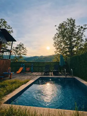 a swimming pool with the sunset in the background at Alyüz Bungalov in Sapanca