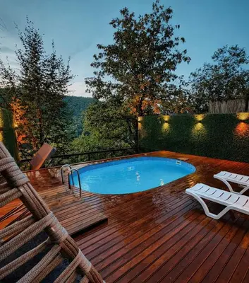 a swimming pool on a wooden deck with two chairs at Alyüz Bungalov in Sapanca