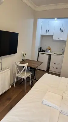 a room with a bed and a table and a kitchen at Balat Life Suites in Istanbul