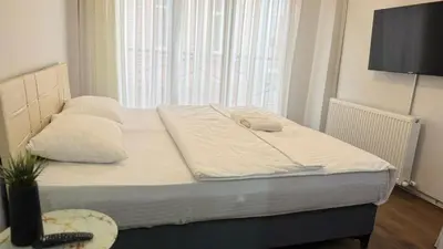 a bed with two pillows and a television in a room at Balat Life Suites in Istanbul
