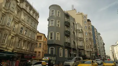 a tall building on a city street with cars at Taksim Armoni Hotel in Istanbul