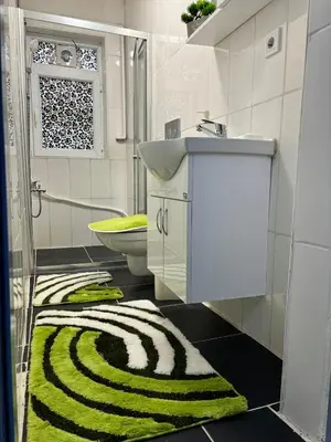 a bathroom with a sink and a green and white rug at Cozy yellow home in Istanbul