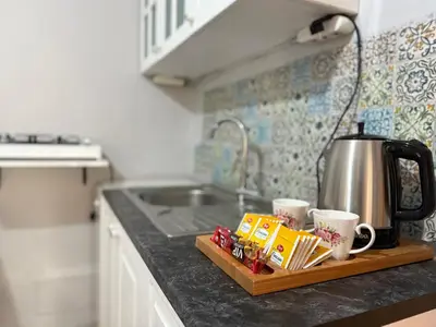 a kitchen counter with a tea kettle and coffee cups at Cozy yellow home in Istanbul