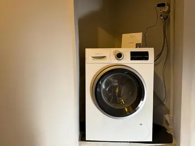 a washer and dryer in a corner of a room at Cozy yellow home in Istanbul