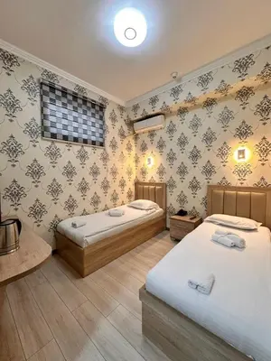 a bedroom with two beds and a wall with wallpaper at Elma hotel in Istanbul