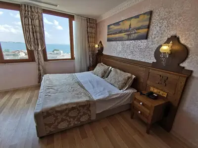 a bedroom with a bed and two windows at Perapolis Hotel in Istanbul