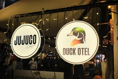 two signs on the wall of a store at Duck Hotel in Istanbul