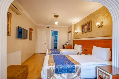 a hotel room with two beds and a table at Big Apple hotel istanbul in Istanbul