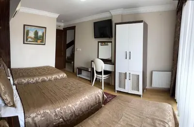 a hotel room with two beds and a desk at ESEN PALAS otel in Istanbul