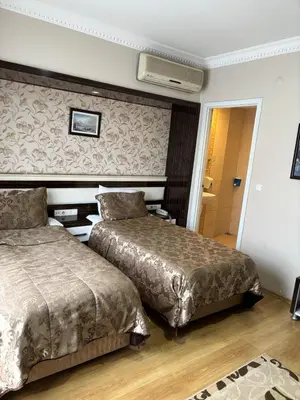 a hotel room with two beds and a hallway at ESEN PALAS otel in Istanbul
