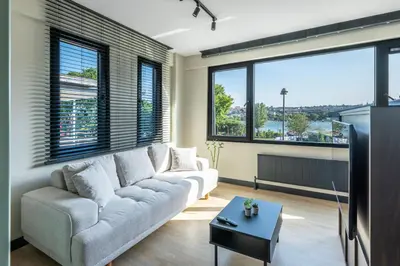 a living room with a couch and large windows at Historic34 Modern Cozy Apartment Golden Horn in Istanbul