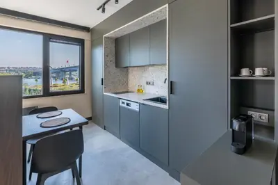 a kitchen with gray cabinets and a table and a window at Historic34 Modern Cozy Apartment Golden Horn in Istanbul