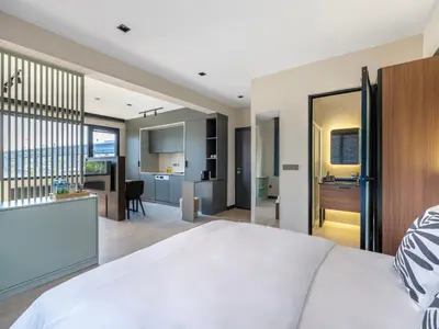 a bedroom with a large white bed and a kitchen at Historic34 Modern Cozy Apartment Golden Horn in Istanbul