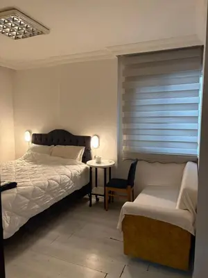 a bedroom with a bed and a chair and a table at Üsküdar Sahil Konaklama in Istanbul