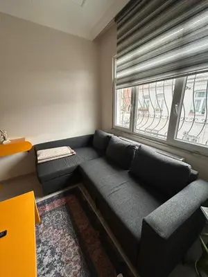 a living room with a couch and a window at Bohemian Antique House in Colorful Balat in Istanbul