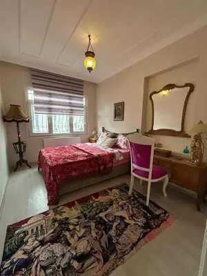 a bedroom with a bed and a chair and a mirror at Bohemian Antique House in Colorful Balat in Istanbul