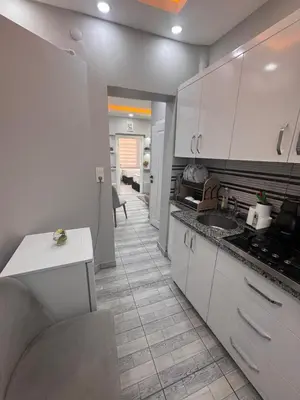 a kitchen with white cabinets and a tile floor at WhiteBird Apartments in Istanbul