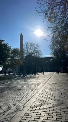 a cobblestone street with a tall building in the background at Çatal hostel in Istanbul